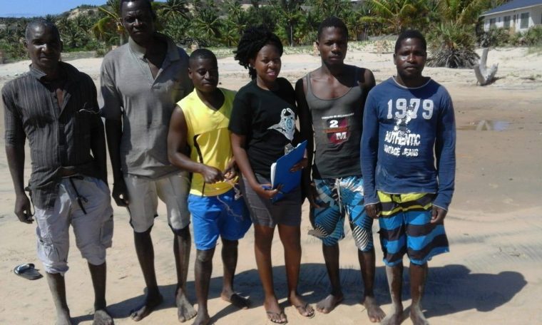 six people standing on a beach