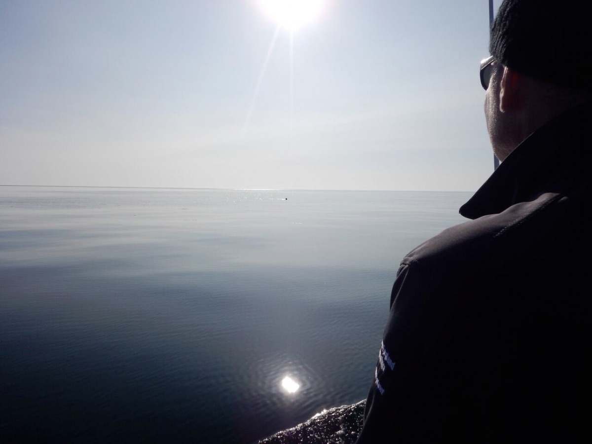 Man looking at large, calm body of water