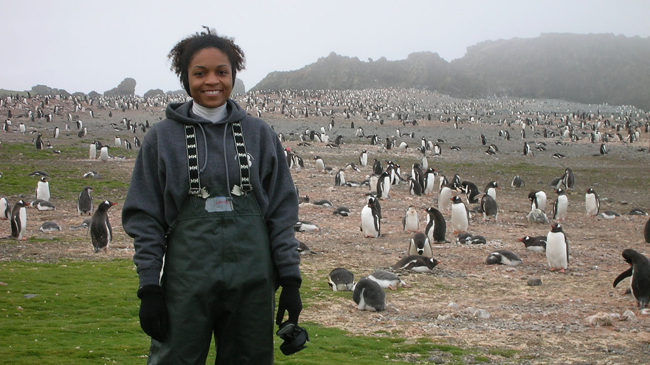 LaFeir with penguins during a trip to Antarctica