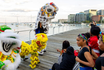 A lion dance troupe performs at the New England Aquarium for a Fierce Urgency of Now festival event