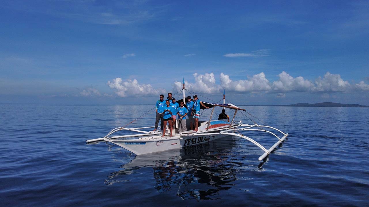 A group on a small catamaran for a whale survey in the Phillippines