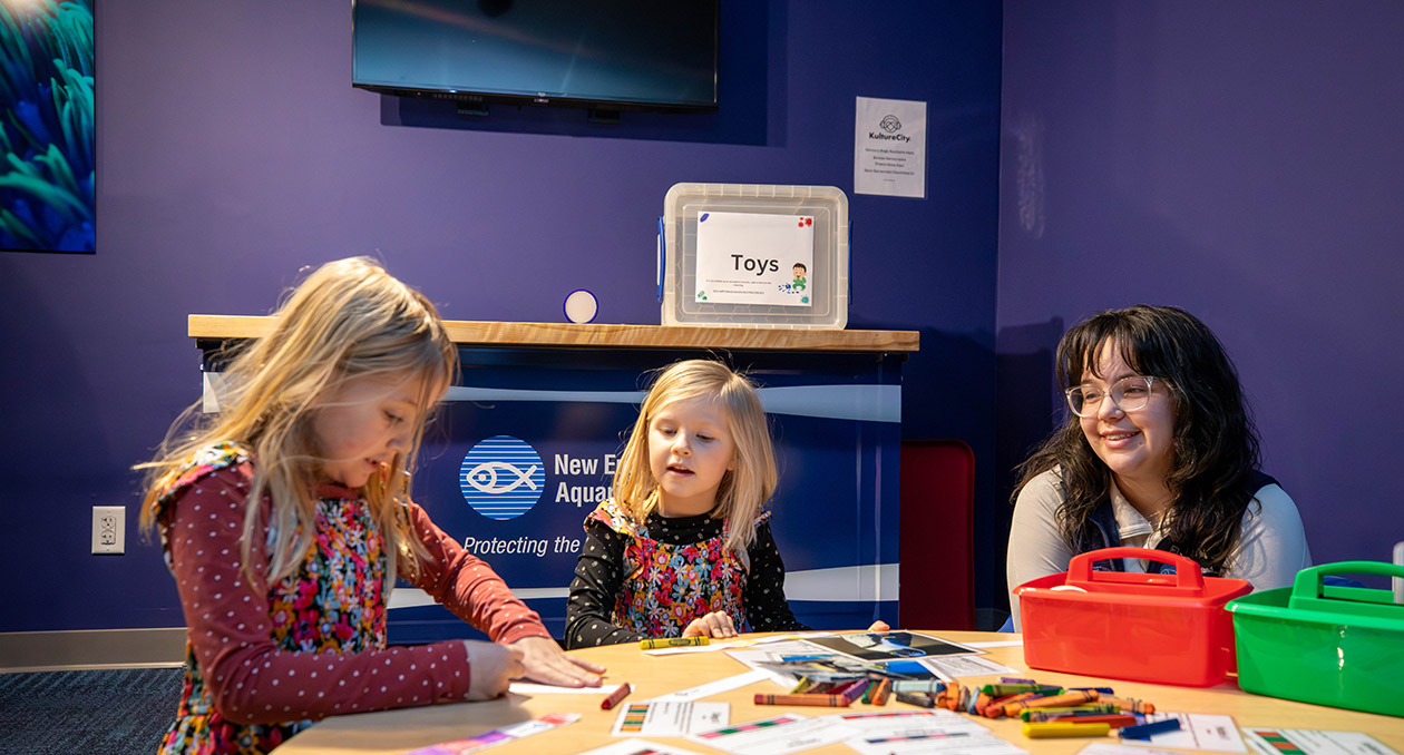 Young learners sit with an Aquarium educator at Exploration Station